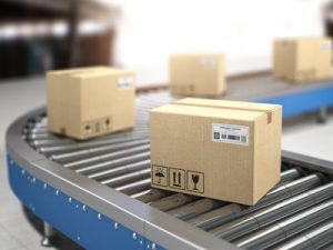 Cartons d'expédition étiquetés sur un convoyeur dans le secteur logistique et e-commerce